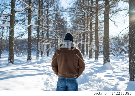 Lonely man walking through snowy winter park Lonely man walking through snowy winter park 142293380