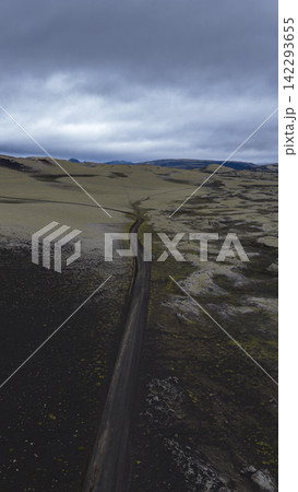 Aerial view of dirt road cutting through lava fields and moss-covered terrain, Skaft?rhreppr Iceland Aerial view of dirt road cutting through lava fields and moss-covered terrain, Skaft?rhreppr Iceland 142293655