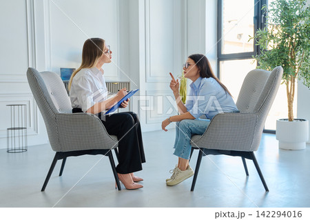 Psychologist consulting female patient during therapy session in modern office Psychologist consulting female patient during therapy session in modern office 142294016