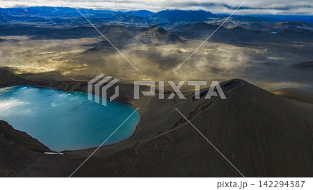 Aerial view of crater lake with turquoise water and dark volcanic cone, ytra Iceland Aerial view of crater lake with turquoise water and dark volcanic cone, ytra Iceland 142294387