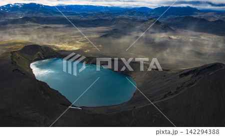 Aerial view of geothermal crater lake with turquoise water, dark volcanic rim, ytra Iceland Aerial view of geothermal crater lake with turquoise water, dark volcanic rim, ytra Iceland 142294388