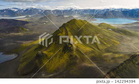 Aerial view of moss-covered volcanic cone with turquoise glacial lake, ytra Iceland Aerial view of moss-covered volcanic cone with turquoise glacial lake, ytra Iceland 142294394