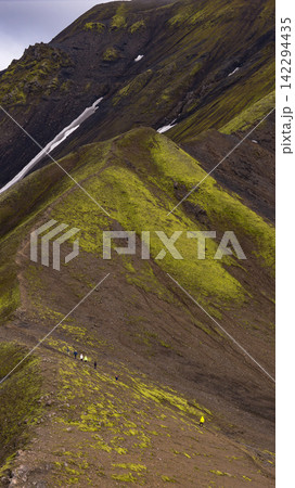 Hikers on moss-covered volcanic slope with meltwater stream, Skaft?rhreppur Iceland Hikers on moss-covered volcanic slope with meltwater stream, Skaft?rhreppur Iceland 142294435