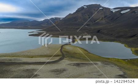 Aerial view of glacial lakes and volcanic mountains with road, ytra Iceland Aerial view of glacial lakes and volcanic mountains with road, ytra Iceland 142294524