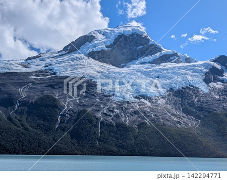 Close View of Glacier Draped Across Rugged Mountain Slopes 142294771