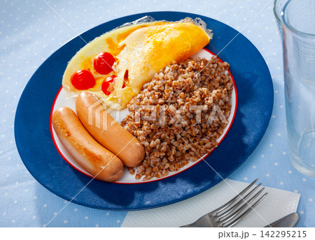 Buckwheat porridge with omelet and boiled sausages Buckwheat porridge with omelet and boiled sausages 142295215