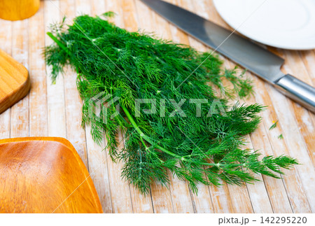 Fresh dill sprigs on kitchen table Fresh dill sprigs on kitchen table 142295220