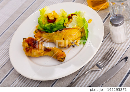 Baked chicken pieces with salad of lettuce and corn 142295271