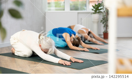 Elderly woman doing yoga in fitness studio Elderly woman doing yoga in fitness studio 142295514
