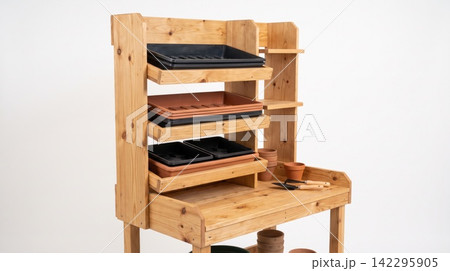 Wooden potting table with multiple tiered shelves and seed trays in a bright studio workstation agriculture equipment cultivation accessory organizer structure flowerpot container furniture Wooden potting table with multiple tiered shelves and seed trays in a bright studio workstation agriculture equipment cultivation accessory organizer structure flowerpot container furniture 142295905