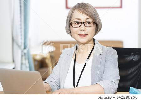オフィスで仕事をするシニア女性 オフィスで仕事をするシニア女性 142296268