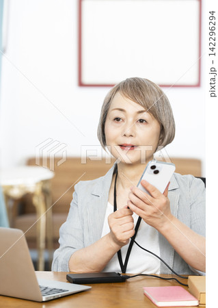 オフィスで仕事をするシニア女性 142296294