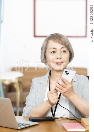オフィスで仕事をするシニア女性 オフィスで仕事をするシニア女性 142296295