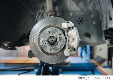Brake system detail, high-performance caliper on car disc brakes. Automotive repair service for mechanical maintenance. 142298433