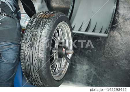 Closeup of car wheel alignment at auto repair center. Vehicle maintenance service in an automotive workshop Closeup of car wheel alignment at auto repair center. Vehicle maintenance service in an automotive workshop 142298435
