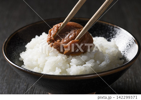 炊きたての白ご飯に梅干しをのせる和食のイメージ 142299371