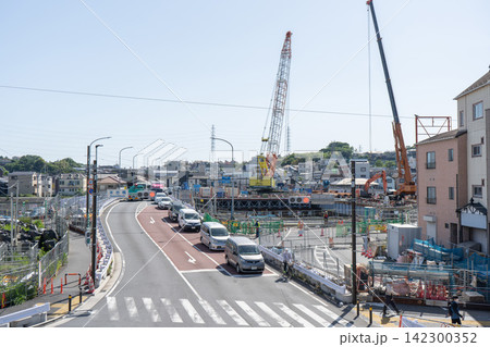 仮設橋を通行する車両と末吉橋の架け替え工事現場 142300352