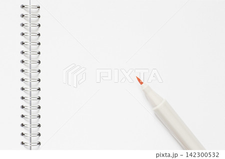 orange marker laying on blank page of sketchbook orange marker laying on blank page of sketchbook 142300532