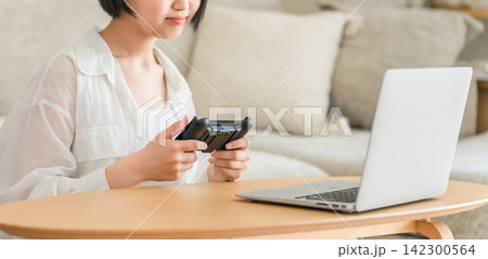 リビングでゲームをする若いアジア人女性 リビングでゲームをする若いアジア人女性 142300564