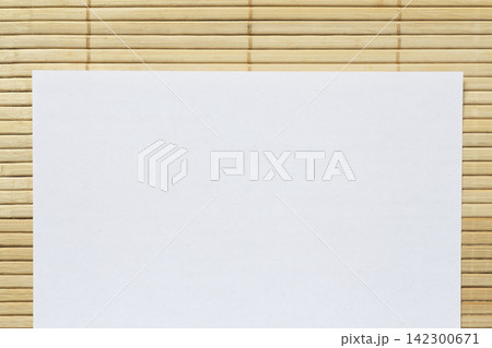 blank white sheet of paper on bamboo mat 142300671