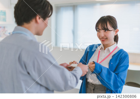 ときめきを隠せない笑顔で封筒を受け取る女性のオフィスラブシーン ときめきを隠せない笑顔で封筒を受け取る女性のオフィスラブシーン 142300806