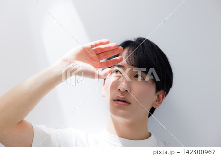 洗面所で鏡を見る若い男性 洗面所で鏡を見る若い男性 142300967