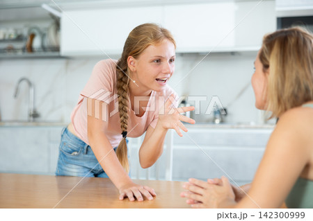 Teenage daughter enthusiastically tells unrecognizable mother about planned vacation with friends Teenage daughter enthusiastically tells unrecognizable mother about planned vacation with friends 142300999