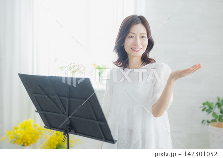 自宅で歌のレッスンをする女性 142301052