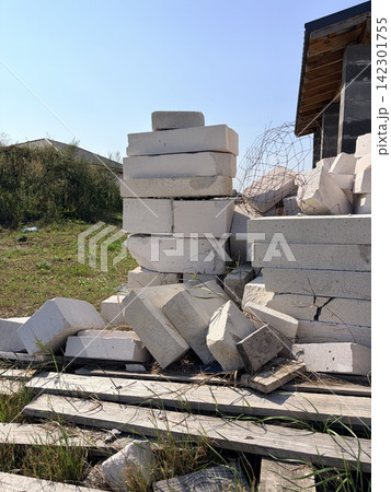 A pile of aerated concrete blocks and construction waste on wooden pallets. The rough and busy nature of building work A pile of aerated concrete blocks and construction waste on wooden pallets. The rough and busy nature of building work 142301755