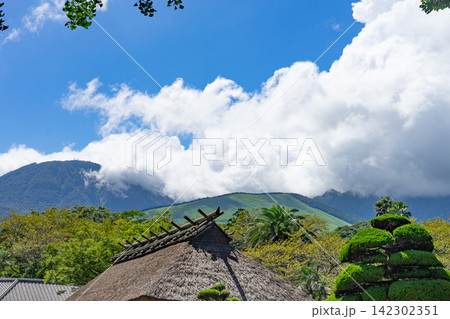 大きな夏雲と緑の山を望む伝統的な茅葺き屋根 大きな夏雲と緑の山を望む伝統的な茅葺き屋根 142302351