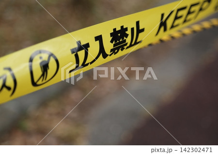 立ち入り禁止の文字が印刷された黄色い規制テープをクローズアップで撮影した写真。 142302471