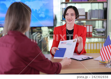 Lawyer gives approved visa documents and passport to client Lawyer gives approved visa documents and passport to client 142302838