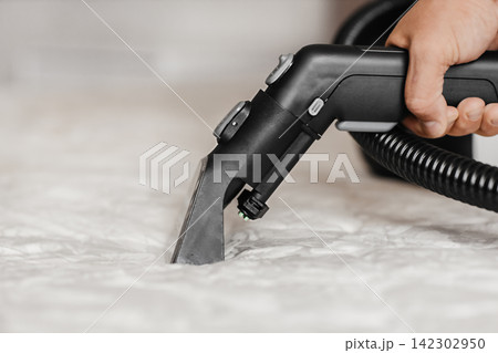Close up of professional extraction vacuum cleaner nozzle cleaning mattress surface 142302950
