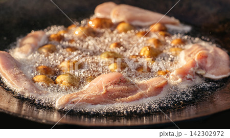 Chicken and Baby Potatoes Frying on Outdoor Griddle 142302972