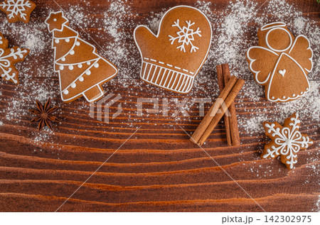 Christmas Gingerbread Cookies with Cinnamon on Wooden Background Christmas Gingerbread Cookies with Cinnamon on Wooden Background 142302975
