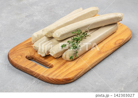Raw White Sausages with Thyme on Wooden Board Raw White Sausages with Thyme on Wooden Board 142303027