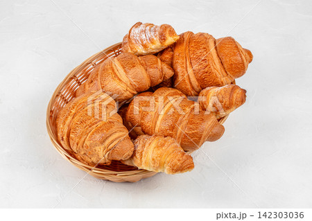 Fresh Golden Croissants in Wicker Basket 142303036