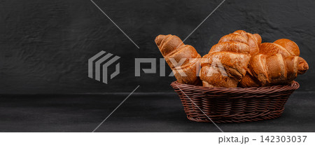 Basket of Croissants on Dark Background with Copy Space 142303037