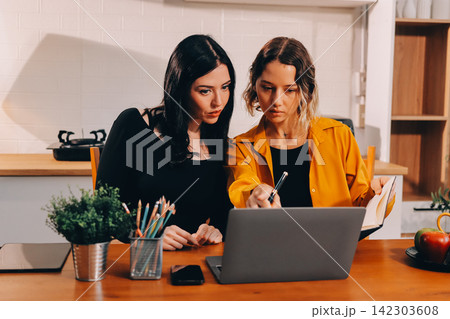 Portrait of military mother helping teen daughter with homework and eating lunch Portrait of military mother helping teen daughter with homework and eating lunch 142303608