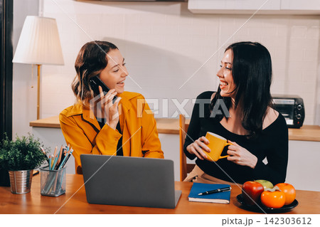 Portrait of military mother helping teen daughter with homework and eating lunch Portrait of military mother helping teen daughter with homework and eating lunch 142303612
