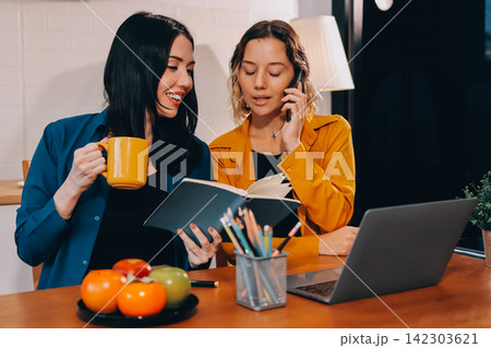 Portrait of military mother helping teen daughter with homework and eating lunch Portrait of military mother helping teen daughter with homework and eating lunch 142303621
