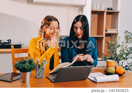 Portrait of military mother helping teen daughter with homework and eating lunch Portrait of military mother helping teen daughter with homework and eating lunch 142303625