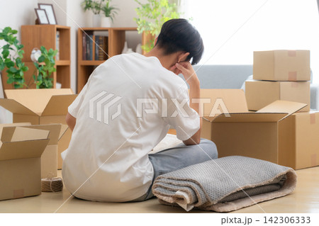 引っ越しの荷造りをする若い男性 142306333