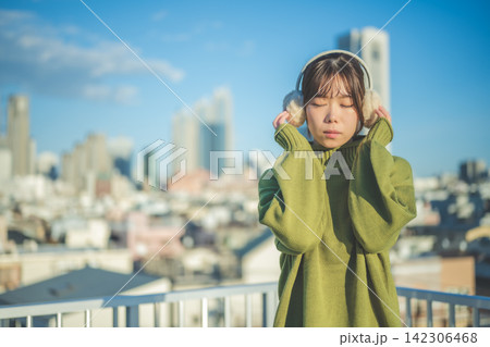 目を閉じてヘッドホンで音楽に聴き入る女性 目を閉じてヘッドホンで音楽に聴き入る女性 142306468