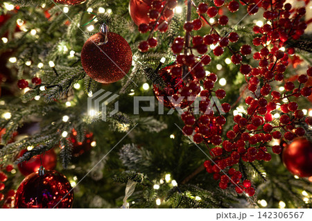 Christmas Background with Red Berries, Evergreen Branches and Warm Red Bokeh Lights. Christmas Background with Red Berries, Evergreen Branches and Warm Red Bokeh Lights. 142306567