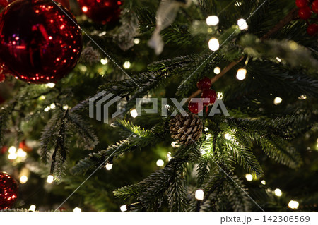 Christmas Pine Branches with Warm String Lights and Pine Cone Christmas Pine Branches with Warm String Lights and Pine Cone 142306569