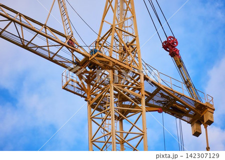 Lattice structure of a yellow tower crane against cloudy sky Lattice structure of a yellow tower crane against cloudy sky 142307129