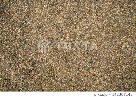 Brown quarry sand layer close-up with uneven mineral grain density, highlighting earthy tones and rough 142307143