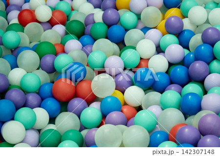 Detailed high angle close up shot of a massive pile of multicolored plastic balls in a children dry playground pool 142307148