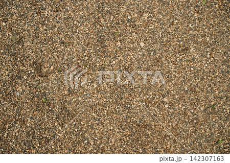 Flat lay of granular sandy soil ground surface, ideal for natural wallpaper, textured screensavers 142307163